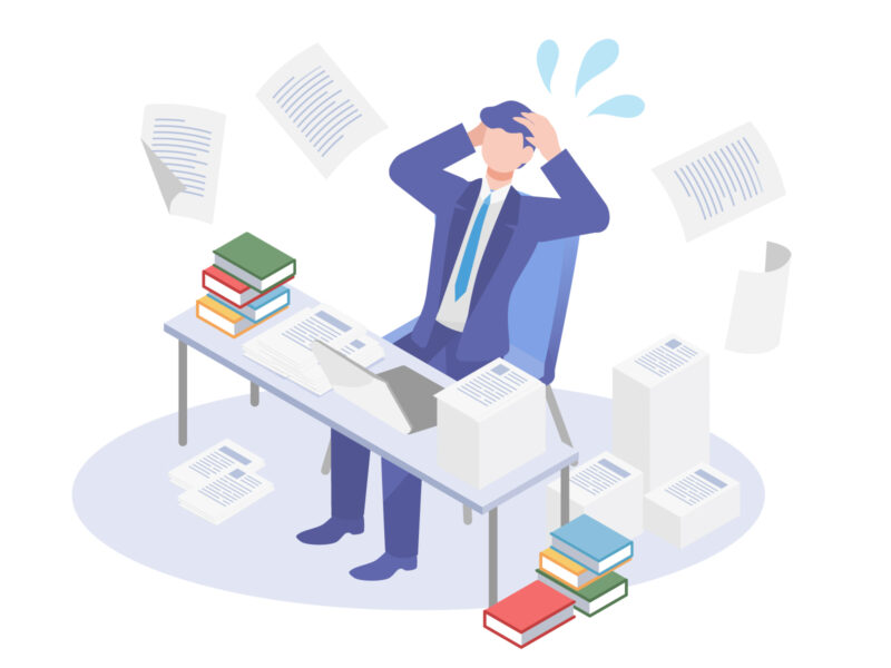 Overwhelmed businessperson at a cluttered desk, papers flying around, stacks of books, and a laptop and printer nearby.